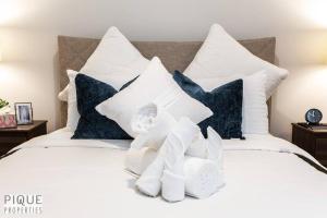 a bed with white pillows and stuffed animals on it at NEW Modern 2 Bedroom Suite, Complimentary Netflix, Sleeps 4 in Edmonton