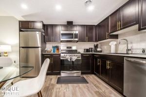 a kitchen with wooden cabinets and a stainless steel refrigerator at NEW Modern 2 Bedroom Suite, Complimentary Netflix, Sleeps 4 in Edmonton