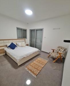 1 dormitorio con 1 cama grande y 1 silla en Ben house, en Tiberíades