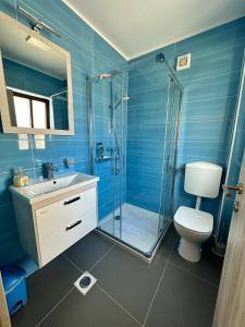 a blue bathroom with a toilet and a shower at APARTMA ALMA in Bovec