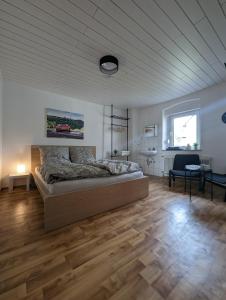 a bedroom with a bed in a room with wooden floors at Pensionszimmer Larifari in Drees