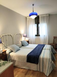 1 dormitorio con 2 camas y manta azul en Apartamento en OVIEDO,WIFI, en Oviedo