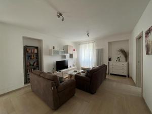 a living room with two couches and a tv at Appartato a 5 minuti dal mare in Imperia