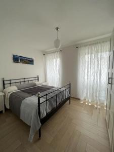 1 dormitorio con 1 cama en una habitación con cortinas en Appartato a 5 minuti dal mare, en Imperia