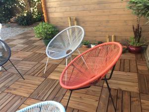 drie stoelen op een houten terras met een tafel bij Chambre avec Spa et Sauna privatisés in Bourg-en-Bresse