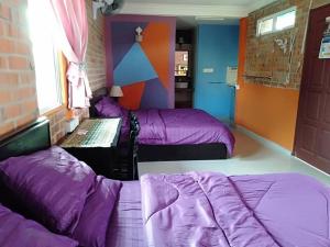 Habitación con 3 camas y escritorio. en Homestay Syams, en Kampong Kubang Bemban