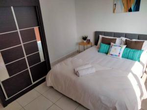 a bedroom with a large white bed with pillows at Damansara Perdana 3BR for 3-7 Guest Near Ikea in Petaling Jaya