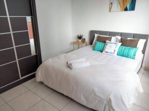 a bedroom with a large white bed with pillows at Damansara Perdana 3BR for 3-7 Guest Near Ikea in Petaling Jaya