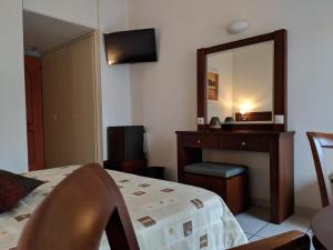 a bedroom with a bed and a mirror and a desk at LEPANTO BEACH HOTEL in Nafpaktos