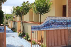un bâtiment avec une clôture arborée et un trottoir dans l'établissement Hotel Residence La Darsena, à Agropoli