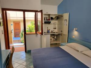 a blue bedroom with a bed and a kitchen at Hotel Residence La Darsena in Agropoli