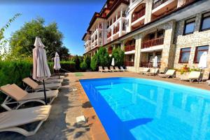 einen Pool vor einem Hotel mit Stühlen und Sonnenschirmen in der Unterkunft Two room apartment in Etara 3, Sveti Vlas in Sweti Wlas