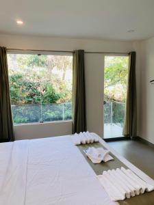 a bedroom with a white bed with a large window at SATRA WAYANAD in Kalpetta