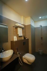 a bathroom with a sink and a toilet and a shower at SATRA WAYANAD in Kalpetta