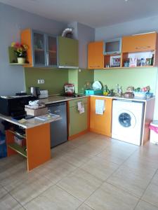 eine Küche mit orangen und grünen Schränken und einer Waschmaschine in der Unterkunft Two room apartment in Etara 3, Sveti Vlas in Sweti Wlas