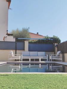 un patio con sillas, una mesa y una piscina en Casa, parque natural de Montserrat cerca Barcelona, en Collbató