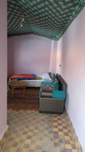 ein Wohnzimmer mit einem Sofa und einem Bett in der Unterkunft Riad Espagne in Marrakesch