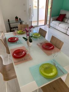 un tavolo con piatti rossi e gialli e bicchieri da vino di Coral Dream ad Alghero