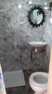 ein Badezimmer mit einem Waschbecken, einem WC und einem Spiegel in der Unterkunft Riad Espagne in Marrakesch