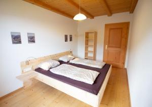 1 dormitorio con cama de madera en una habitación en Biohof Unterstein, en Ultimo