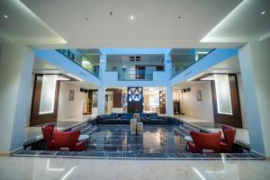a lobby with couches and chairs in a building at Kyriad Prestige Ilkal in Ilkal