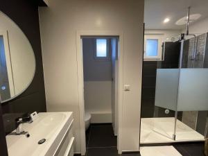 a bathroom with a sink and a toilet and a mirror at Très bel appartement T3 centre ville, commerces et gare in Rambouillet