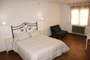 a bedroom with a large bed and a chair at Casa Pedro Páez in Belmonte