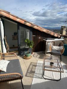 eine Terrasse mit Stühlen und einem Tisch auf dem Dach in der Unterkunft Terrasse, panoramique in Châteauneuf-de-Gadagne