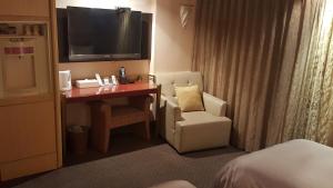台北的住宿－台北新月商旅，酒店客房配有书桌、椅子和电视。
