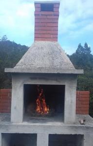 an outdoor pizza oven with a fire in it at Ana in Zaglav