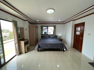a bedroom with a bed and a large window at Rose Garden Guest House Soi 88 Hua Hin in Hua Hin