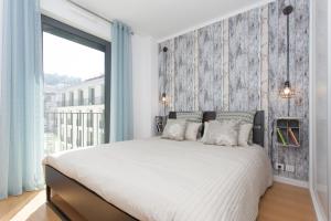 ein Schlafzimmer mit einem großen Bett und einem großen Fenster in der Unterkunft Bairrus Lisbon Apartments - Mello in Lissabon
