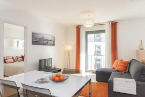 ein Wohnzimmer mit einem Tisch und einem Sofa in der Unterkunft Bairrus Lisbon Apartments - Mello in Lissabon