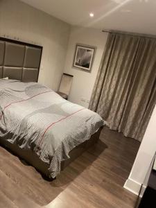een slaapkamer met een groot bed en een raam bij Luxurious Furnished Property in Stanmore