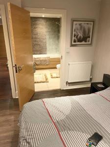 a room with a bed and a door with a bathroom at Luxurious Furnished Property in Stanmore