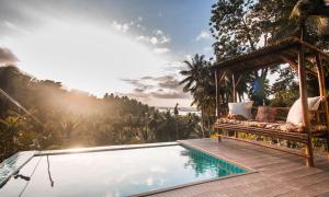 a villa with a swimming pool and a pergola at Villa Kulintang in Donsol