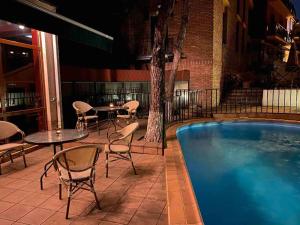 a patio with tables and chairs next to a pool at Betsy"s hotel in Tbilisi City