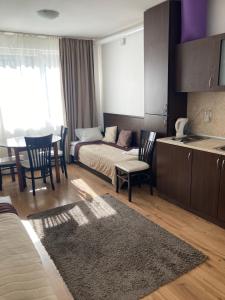een woonkamer met een bed en een tafel en stoelen bij Iglika 2 Ski Apartment in Borovets