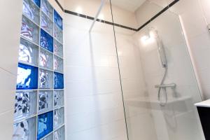 y baño con ducha y azulejos azules y blancos. en Le Brivetain ✩ Hypercentre ✩ Parking gratuit, en Pontchâteau