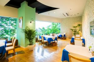 una sala da pranzo con tavoli, sedie e tavoli blu di Hotel Sanderson a Maebashi