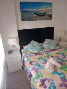 een slaapkamer met een bed en een foto van een boot bij Apartamento Algemsí Cullera in Cullera