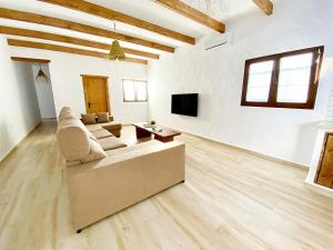 un ampio soggiorno bianco con divano e TV di GALDANA a Chiclana de la Frontera