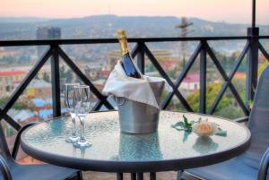 a table with a bottle of wine and two glasses at Betsy"s hotel in Tbilisi City