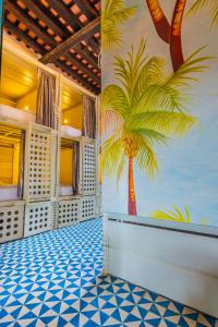 a room with a mural of a palm tree on the wall at República Bahía Santa Marta Hostel in Santa Marta