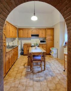a kitchen with wooden cabinets and a table with chairs at Appartamento la Playa in Cagliari