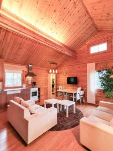 a living room with couches and a table at Peaceful log cabin in the country in Nurmijärvi