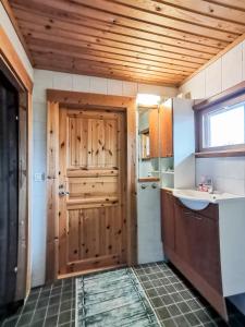 a kitchen with a wooden door and a sink at Peaceful log cabin in the country in Nurmijärvi