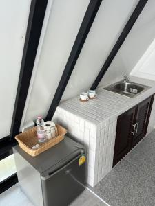a small kitchen with a sink and a small refrigerator at ทุ่งดินดำ Farm Stay in Ban Kho Wang