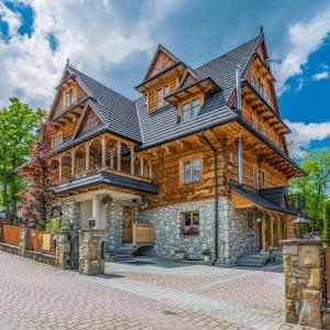 a large wooden house with a black roof at Gościniec Regionalny in Zakopane