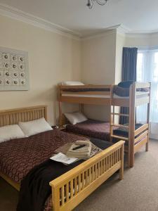 Waverley Park Lodge في بورتسماوث: غرفة نوم بسريرين وسرير بطابقين وكرسي